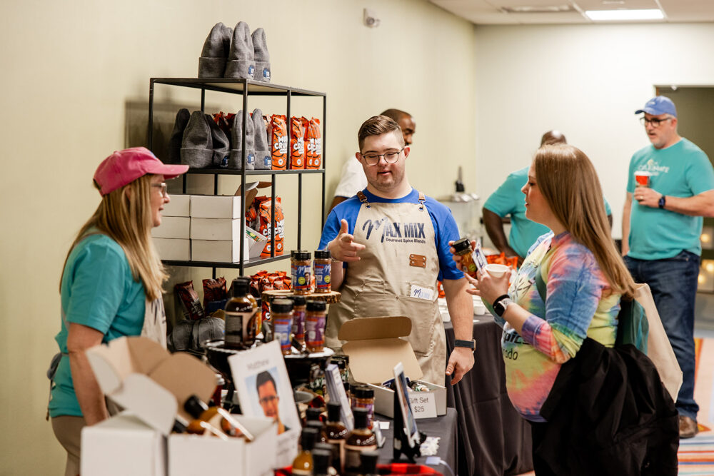 Entrepreneur Max shares information about his business with shoppers at The Celebrate Shop