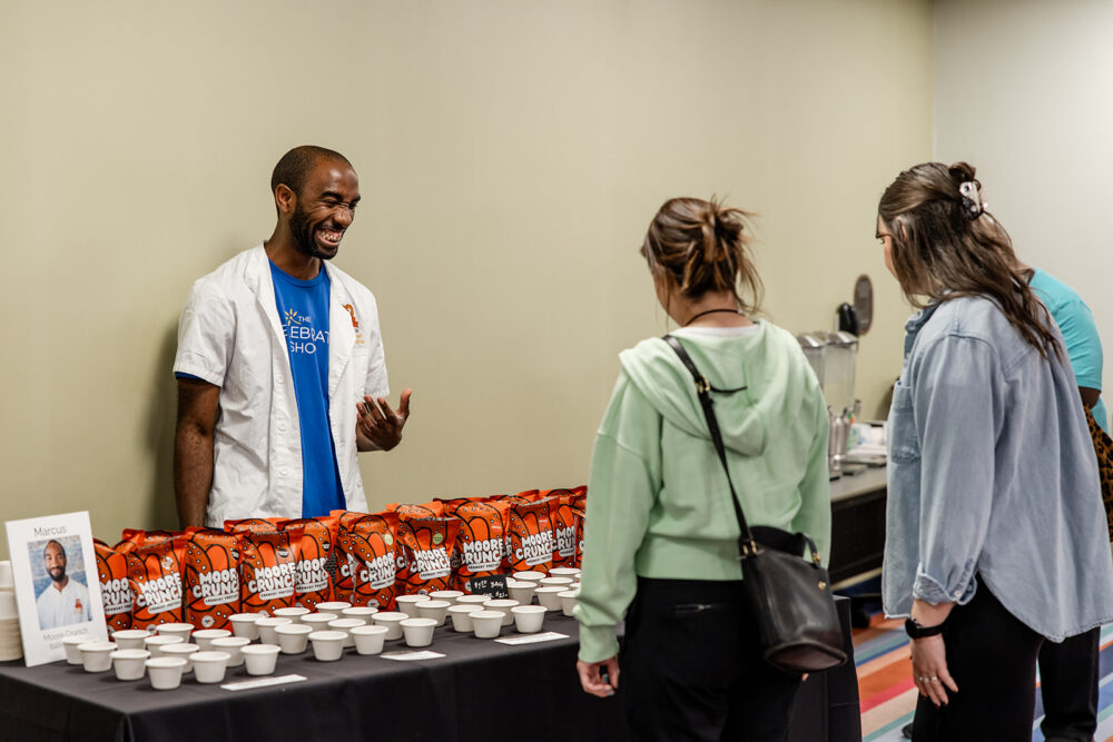 Entrepreneur Marcus shares samples of his products with attendees at The Celebrate Shop